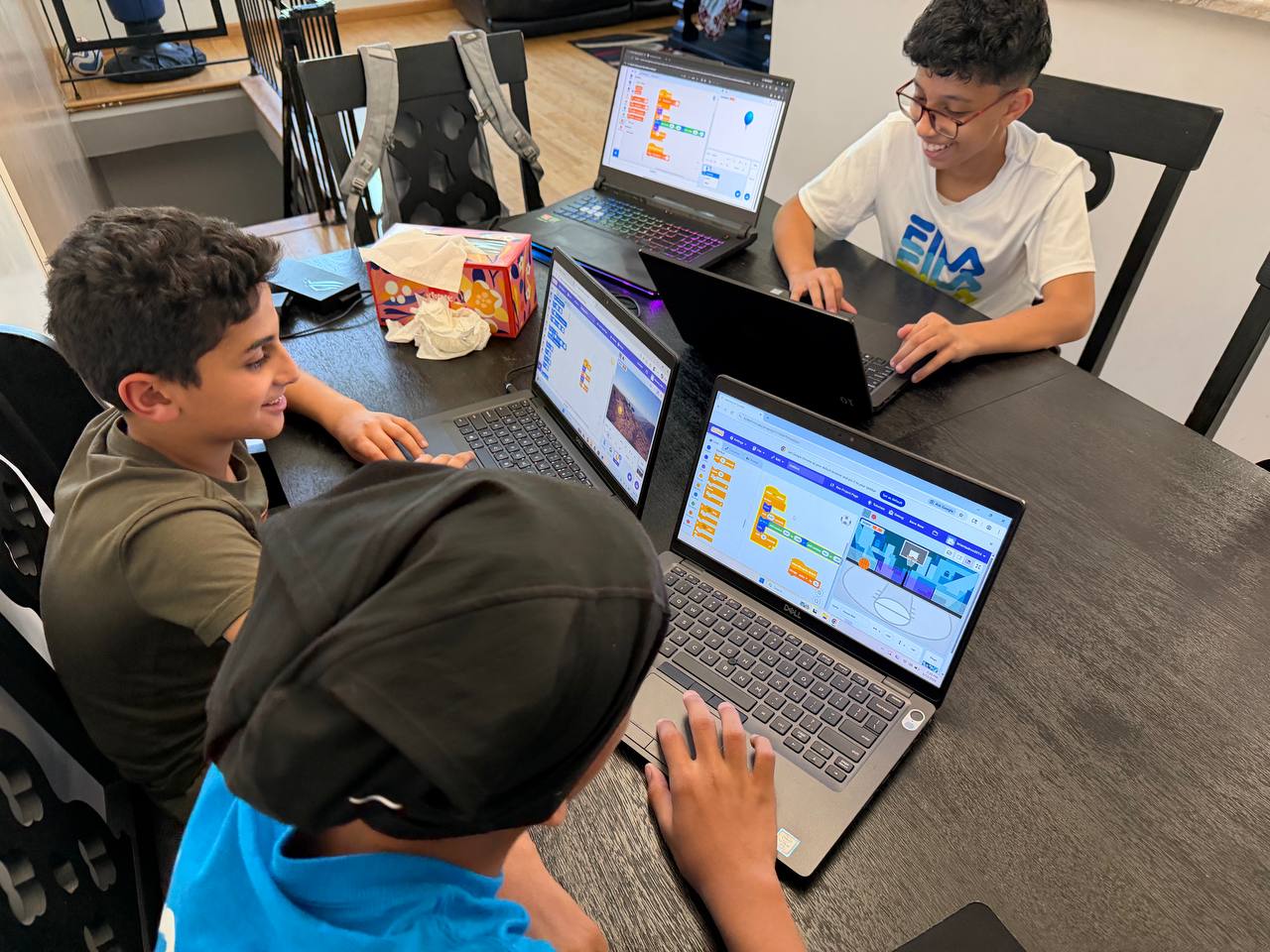 Students building Scratch games on laptops during an AvendraLabs small-group coding session