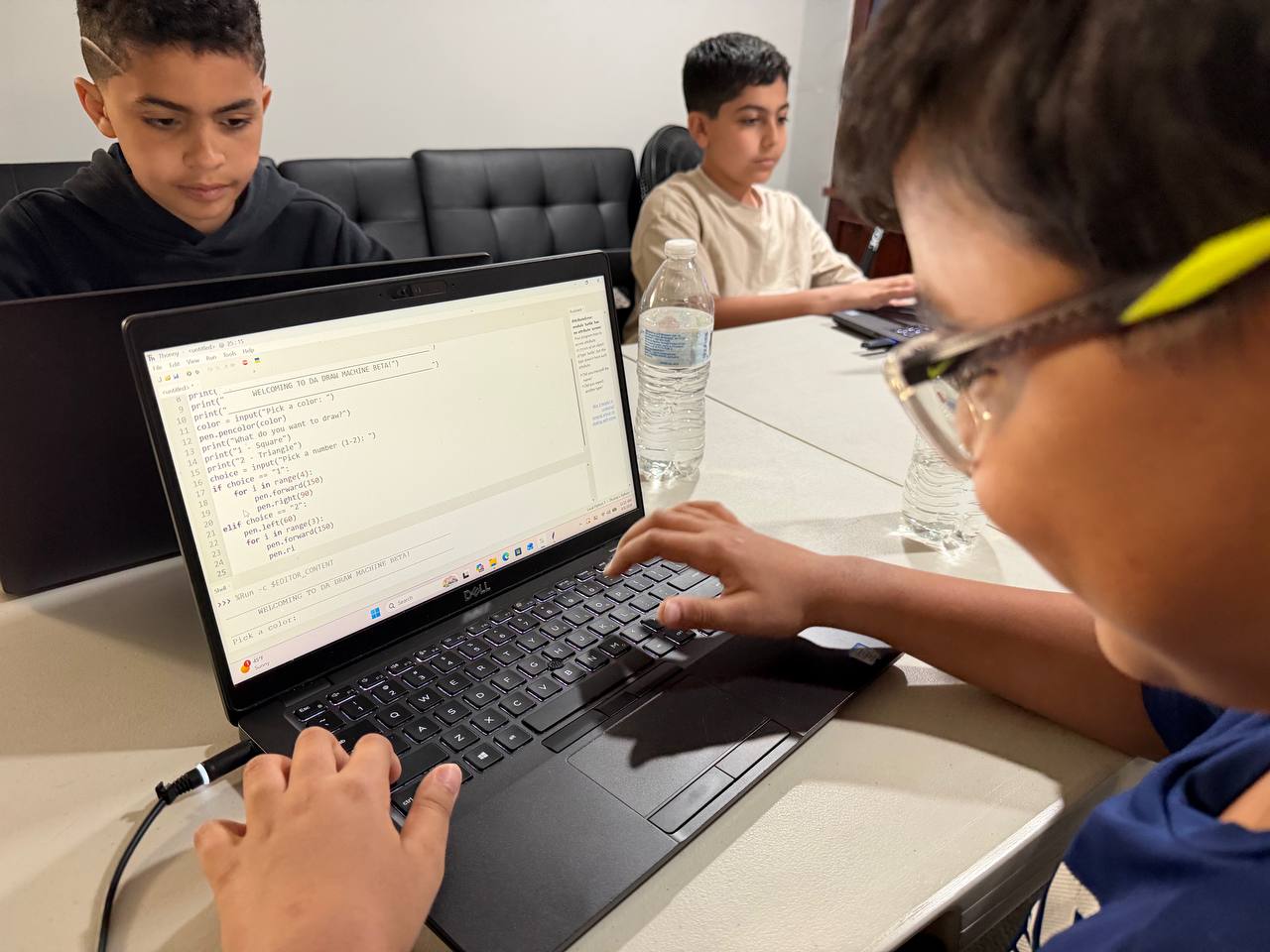 Student typing Python code in an editor during class